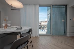 Un comedor con mesa y sillas y una gran ventana. en Metekhi Elegance-Classic Charm in Tbilisi's Heart, en Tiflis