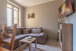 een woonkamer met een bank en een tafel bij Apartament u Renaty in Krynica Zdrój