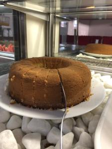 a chocolate cake sitting on a plate on a counter at Pousada Central in Feira de Santana