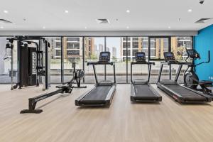 a gym with a row of treadmills at Relaxing Retreat in Meydan in Dubai