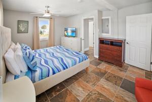 a bedroom with a bed and a dresser and a tv at Beach House with Heated Pool & Family Games in Palm Coast +62 photos