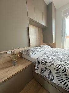 a bedroom with a bed with a black and white comforter at Apartment Mimi in Zadar