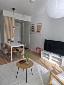 a living room with a table and a tv at Cozy one-bedroom apartment with sauna in Rauma