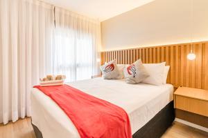 een slaapkamer met een groot bed met een rode deken bij 360 Soma Perdizes in Sao Paulo +46 foto's