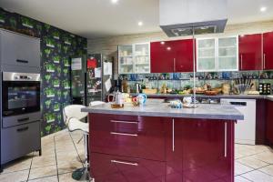 DrulheにあるLe Nid du Colibriの赤いキャビネットと紫色のアイランドを備えたキッチン +21枚の写真