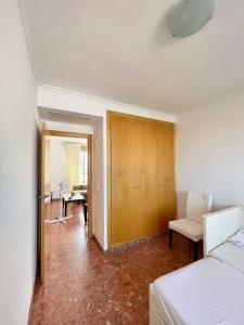 a bedroom with a bed and a chair and a desk at Atico luminoso en Cullera centro. in Cullera
