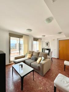 a living room with a couch and a table at Atico luminoso en Cullera centro. in Cullera