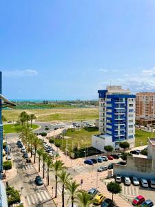 a parking lot with palm trees and a building at Atico luminoso en Cullera centro. in Cullera