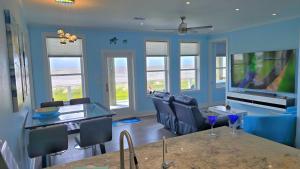 a living room with blue walls and a blue couch at Beachfront - Hot Tub - Home Theater in Bolivar Peninsula +38 photos