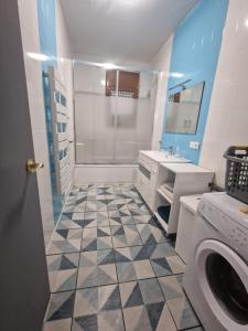 a bathroom with a shower and a washing machine at Casita Flamingo in Deltebre