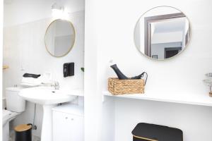 ein weißes Badezimmer mit einem Spiegel und einem Waschbecken in der Unterkunft ChrisAri House in Zipárion + 19 Fotos