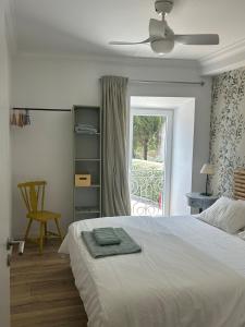 a bedroom with a white bed and a window at Casinha de santo Antonio in Villa Nogueira