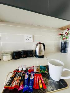 un piano di lavoro con degli snack, una tazza e una tazza da caffè di Lagoon a Pretoria