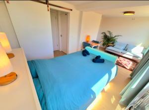 a small room with a blue bed and a couch at Welkom Op Texel privé kamer op het zuiden in De Koog +4 photos