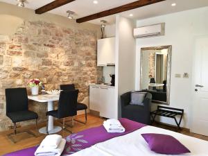 une chambre avec un lit, une table et des chaises dans l'établissement Magnolia Luxury Apartments, à Split