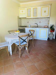 a kitchen with a table and chairs and a sink at Appartamento le querce in Vaccileddi