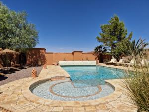 a swimming pool in a yard with a patio at Maison d'hôtes Tigminou - Adults Only in Aït Benhaddou