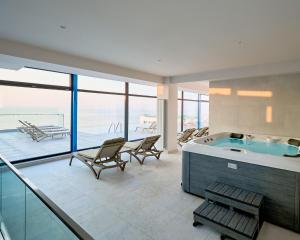 a large bathroom with a jacuzzi tub and chairs at Riviera - Infinity Pool & Spa Resort in Mamaia