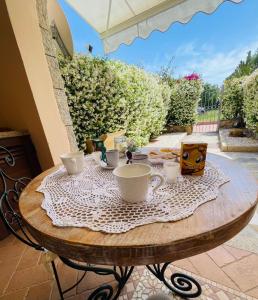 a wooden table with cups and plates on it at Appartamento le querce in Vaccileddi