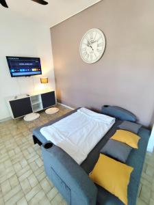 une chambre avec un lit et une horloge au mur dans l'établissement Appartement climatisé avec terrasse 4 à 6 couchages à 600m du centre thermal, à Lamalou-les-Bains