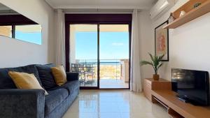 a living room with a blue couch and a television at Coral beach in Peñíscola