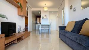 a living room with a blue couch and a television at Coral beach in Peñíscola