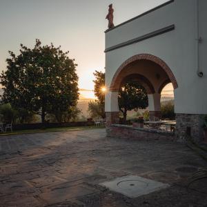 a building with an arch with a sunset in the background at Podere di Montecchio - Le Andane in Tavarnuzze
