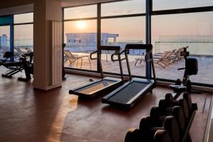 a gym with cardio equipment and a large window at Riviera - Infinity Pool & Spa Resort in Mamaia