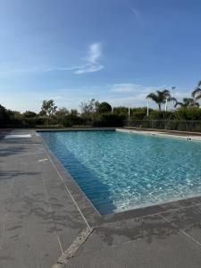 a swimming pool with blue water in a parking lot at appartement 2 pieces avec parking ds résidence in Palavas-les-Flots