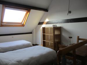 MaarkedalBergs and Cobbles的一间卧室设有两张床、一个窗口和一张桌子