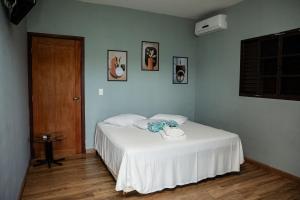 a bedroom with a bed with a phone on it at Pousada No Caminho in Tambaú +40 photos