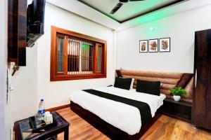 a bedroom with a large bed and a window at HOTEL O BONJOUR .INN NEAR CROWN PLAZA in Noida