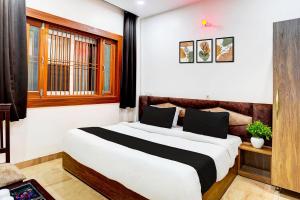 a bedroom with a large bed in a room at HOTEL O BONJOUR .INN NEAR CROWN PLAZA in Noida +34 photos