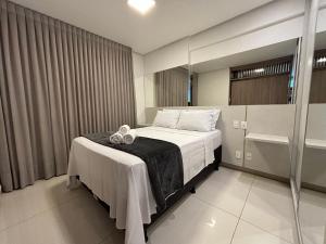 um quarto com uma cama com duas toalhas em LUX26 - Flat Próx Órion Cozinha Completa com Varanda em Goiânia mais 14 fotografias