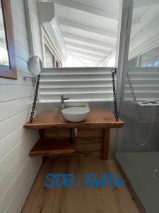 La salle de bains est pourvue d'un lavabo et d'un miroir sur une table. dans l'établissement Haut de villa BEL BO & Bas de villa Tibo accès mer, à Deshaies