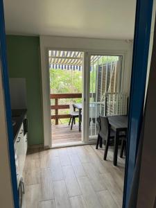 une salle à manger avec une porte menant à une terrasse dans l'établissement Studio A14 près de la mer Village du Diamant, au Diamant