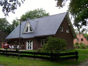 una casa de ladrillo rojo con techo de gambrel en Ferienwohnung Strudthoff, en Ganderkesee