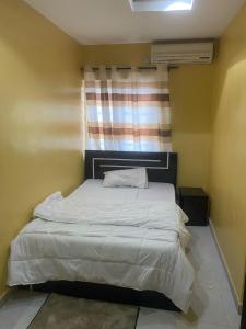 una camera da letto con un letto bianco in una stanza di KB-ALFATIA Intergrated Service a Alimosho