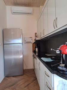 a kitchen with a stainless steel refrigerator and white cabinets at Hotel Albani in Lezhë