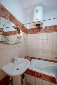 a bathroom with a sink and a mirror and a tub at Dimitri Apartment in Sarandë +15 photos