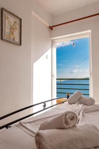 a bedroom with a bed with a large window at Dimitri Apartment in Sarandë