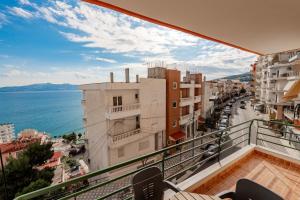 a balcony with a view of the ocean and buildings at Dimitri Apartment in Sarandë