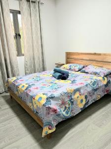 a bed with a floral comforter and pillows on it at Residence Sunset 3 bedrooms appartment Tourists only in Midlands Station +11 photos