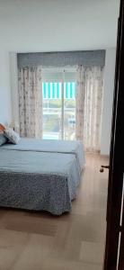 a bedroom with a bed and a large window at Apartamento Aiguablava Playa de Gandía in Playa de Gandia