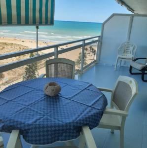 a table and chairs on a balcony with a beach at Apartamento Aiguablava Playa de Gandía in Playa de Gandia