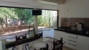 a kitchen with a dining table and a large window at Casa de praia em Itaúna, Saquarema, Pertinho do mar 150 m da areia com 3 quartos e ar condicionado in Saquarema