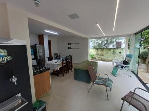 a kitchen and a living room with a table and chairs at Casa de praia em Itaúna, Saquarema, Pertinho do mar 150 m da areia com 3 quartos e ar condicionado in Saquarema +37 photos