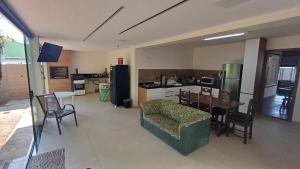 a living room with a table and a kitchen with a couch at Casa de praia em Itaúna, Saquarema, Pertinho do mar 150 m da areia com 3 quartos e ar condicionado in Saquarema