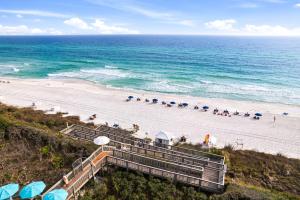 a beach with stairs and umbrellas and the ocean at HP 16E Beach Treat by 30A Escapes in Rosemary Beach