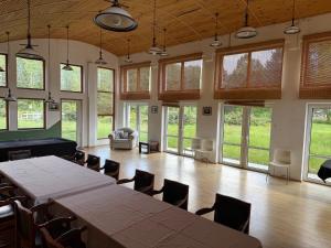 a large room with a table and chairs and windows at Oaza Spokoju Pod Warszawą in Marianka